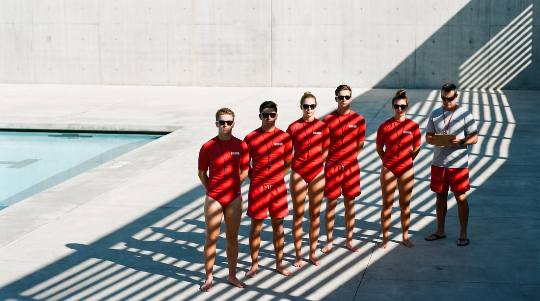 A row of lifeguards in matching red uniforms showing a consistent uniform standard