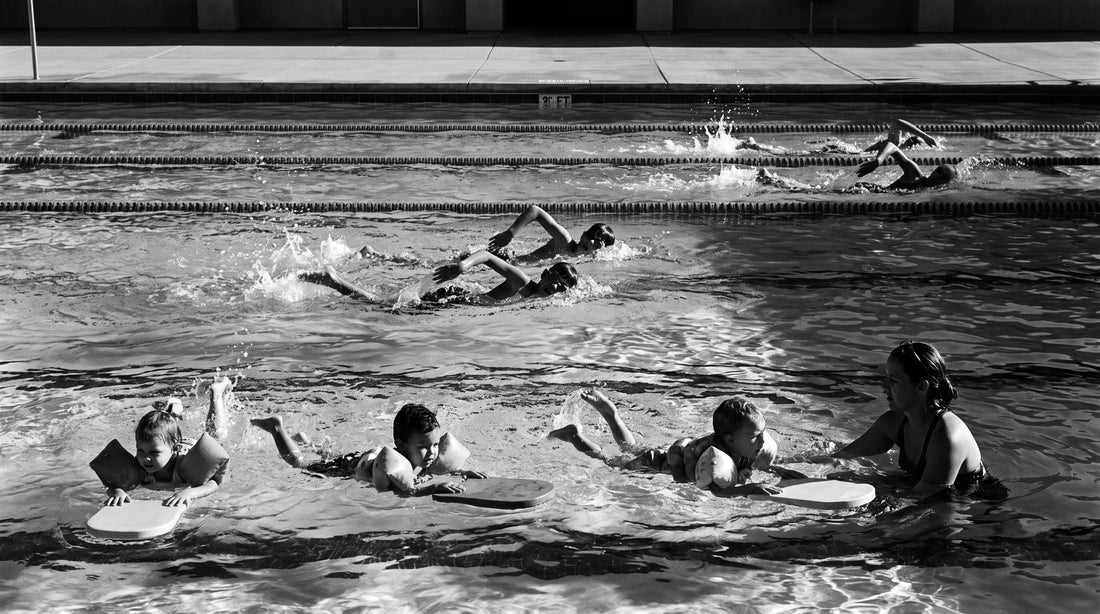 Three swim lesson groups at different ability levels sharing one community pool