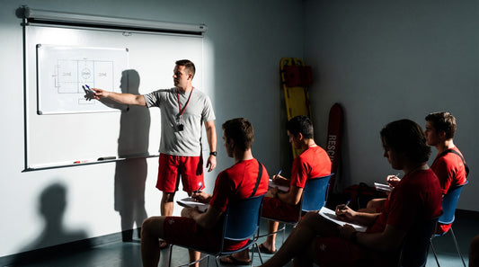 Pre-opening lifeguard in-service briefing with a supervisor at a whiteboard of pool zones