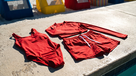 Lifeguard swimwear including a guard one-piece, board shorts and a sun-protective rash top