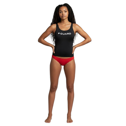 Model wearing The Lifeguard Store black racer back tankini top with white GUARD text and red bikini bottoms