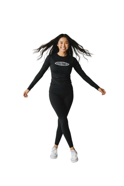 The Lifeguard Store black long sleeve crew neck rashguard with white "INSTRUCTOR" graphic on chest. Made of polyester and spandex.