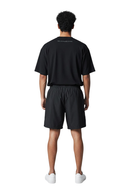 The Lifeguard Store black polyester board shorts with elastic waistband and 7" inseam. Ideal for water activities.