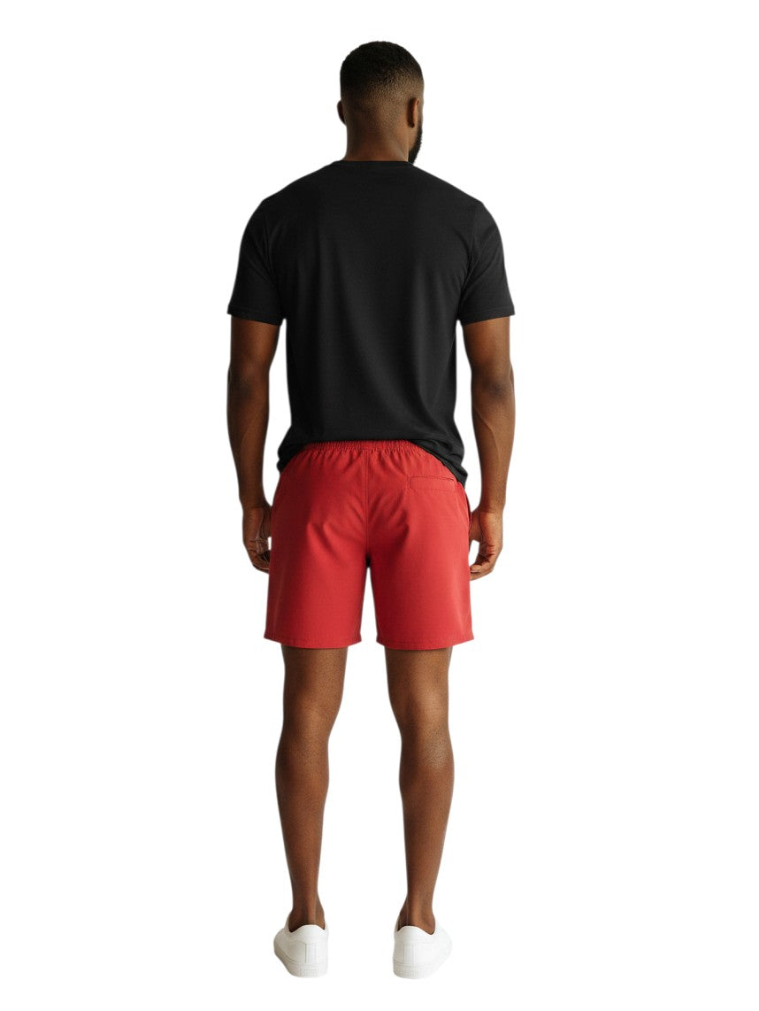 The Lifeguard Store RISE black short sleeve crew neck rashguard worn with red shorts by a man, back view