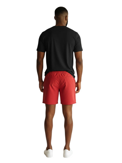 The Lifeguard Store RISE black short sleeve crew neck rashguard worn with red shorts by a man, back view