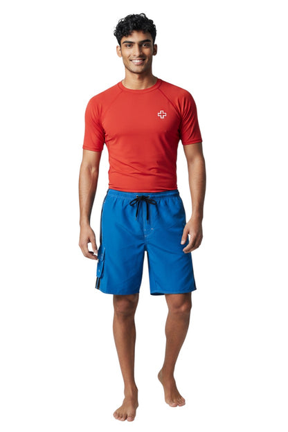 The Lifeguard Store blue polyester board shorts with black side stripes, drawstring waist, and cargo pocket.