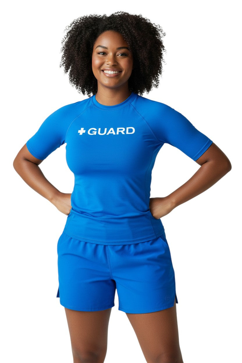 The Lifeguard Store blue short sleeve crewneck rashguard with white "+ GUARD" text on chest. UPF50+.