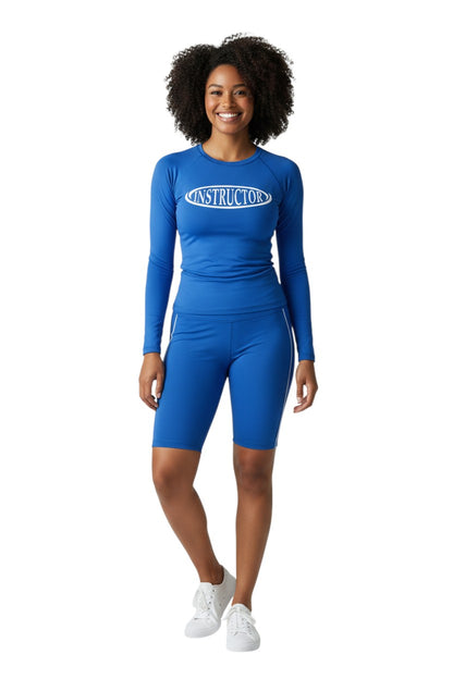 The Lifeguard Store blue long sleeve crew neck rashguard with white oval 'INSTRUCTOR' graphic. UPF50+ protection.