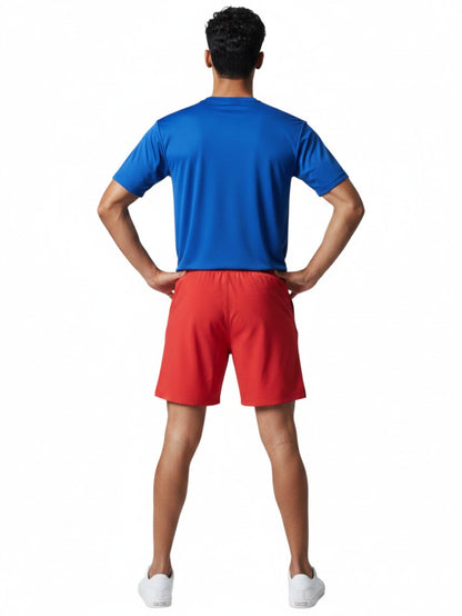 A male lifeguard wearing The Lifeguard Store blue short sleeve crew neck rashguard and red shorts from behind.