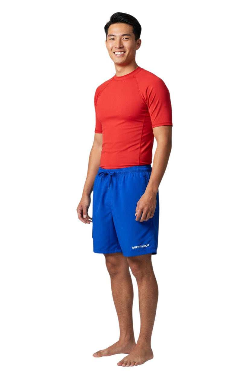The Lifeguard Store blue polyester board shorts with elastic waistband, drawstring, cargo pocket, and "SUPERVISOR" logo.