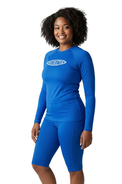 The Lifeguard Store royal blue long sleeve rashguard with white oval 'INSTRUCTOR' graphic. Poly-spandex blend with UPF50+ protection.