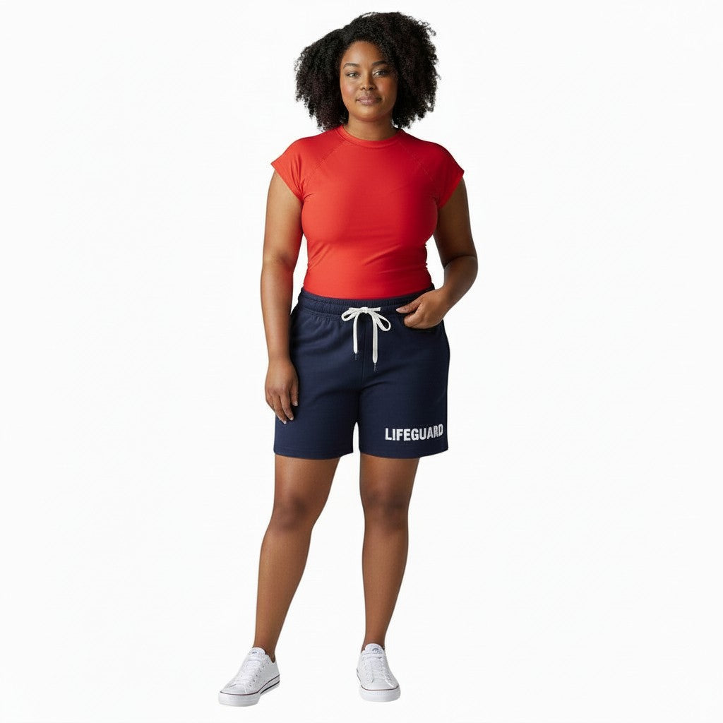 The Lifeguard Store navy blue crew neck rashguard with short sleeves and white drawstring shorts with "LIFEGUARD" text.