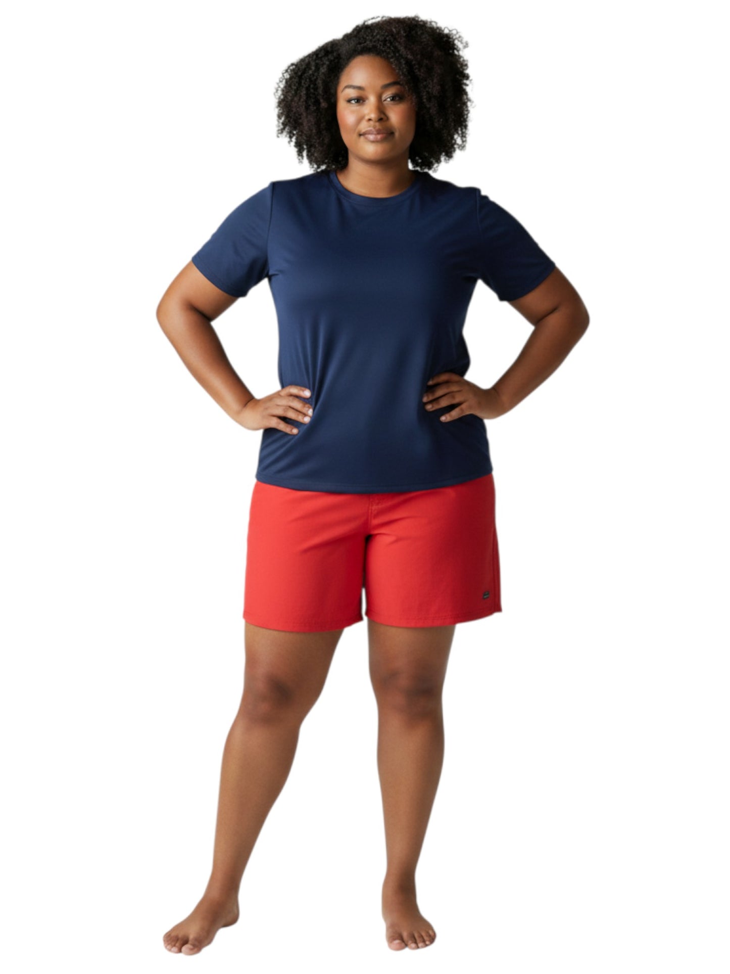 A model wearing The Lifeguard Store navy blue short sleeve crew neck rashguard with red shorts on a white background.