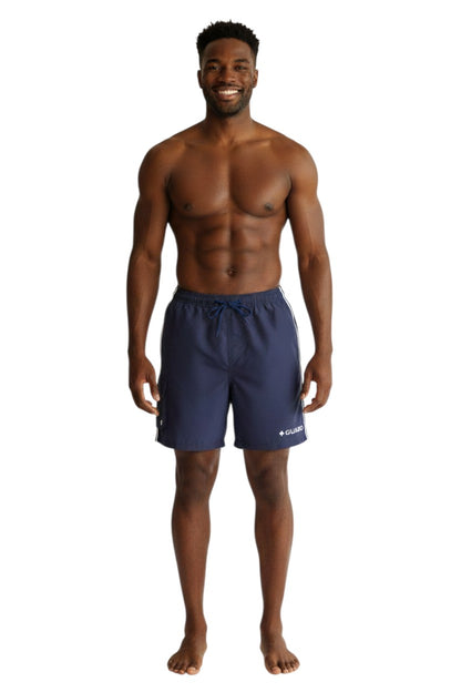 The Lifeguard Store navy blue polyester board shorts with white drawstring and side stripe detail. Features cargo pocket and GUARD logo.