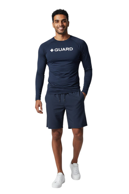 The Lifeguard Store navy blue long sleeve crewneck rashguard with white + GUARD text on chest. Polyester/spandex blend.