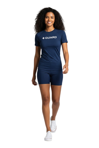 The Lifeguard Store navy blue short sleeve crewneck rashguard with white + GUARD text on chest. Polyester-spandex blend.