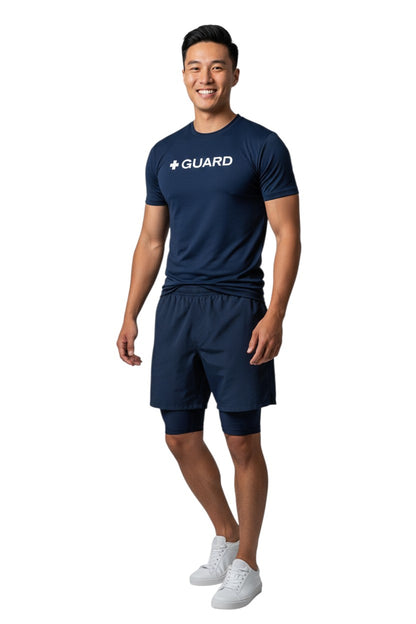 The Lifeguard Store navy blue short sleeve crewneck rashguard with white + GUARD text on chest. Made of polyester and spandex.