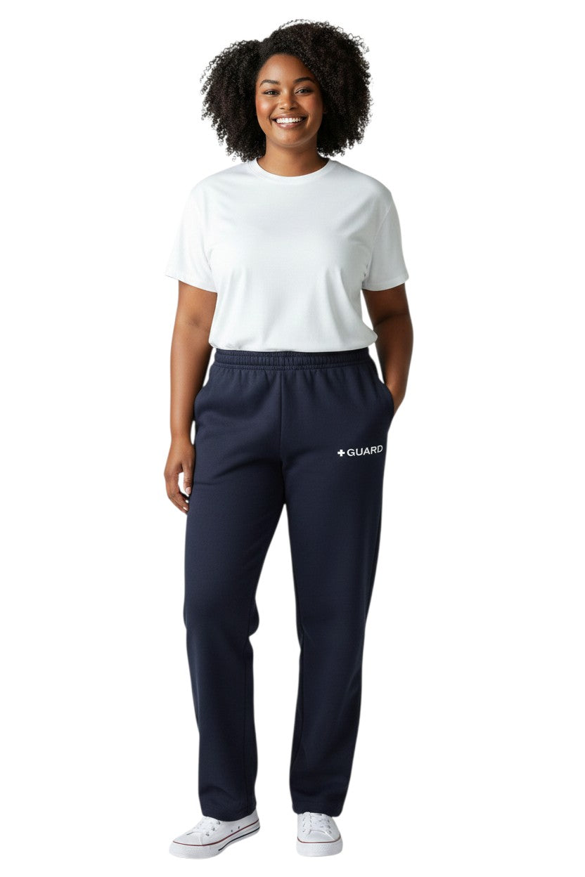 The Lifeguard Store navy blue sweatpants with drawstring and side pockets, featuring a white + GUARD logo. Made of 50% Cotton / 50% Polyester.
