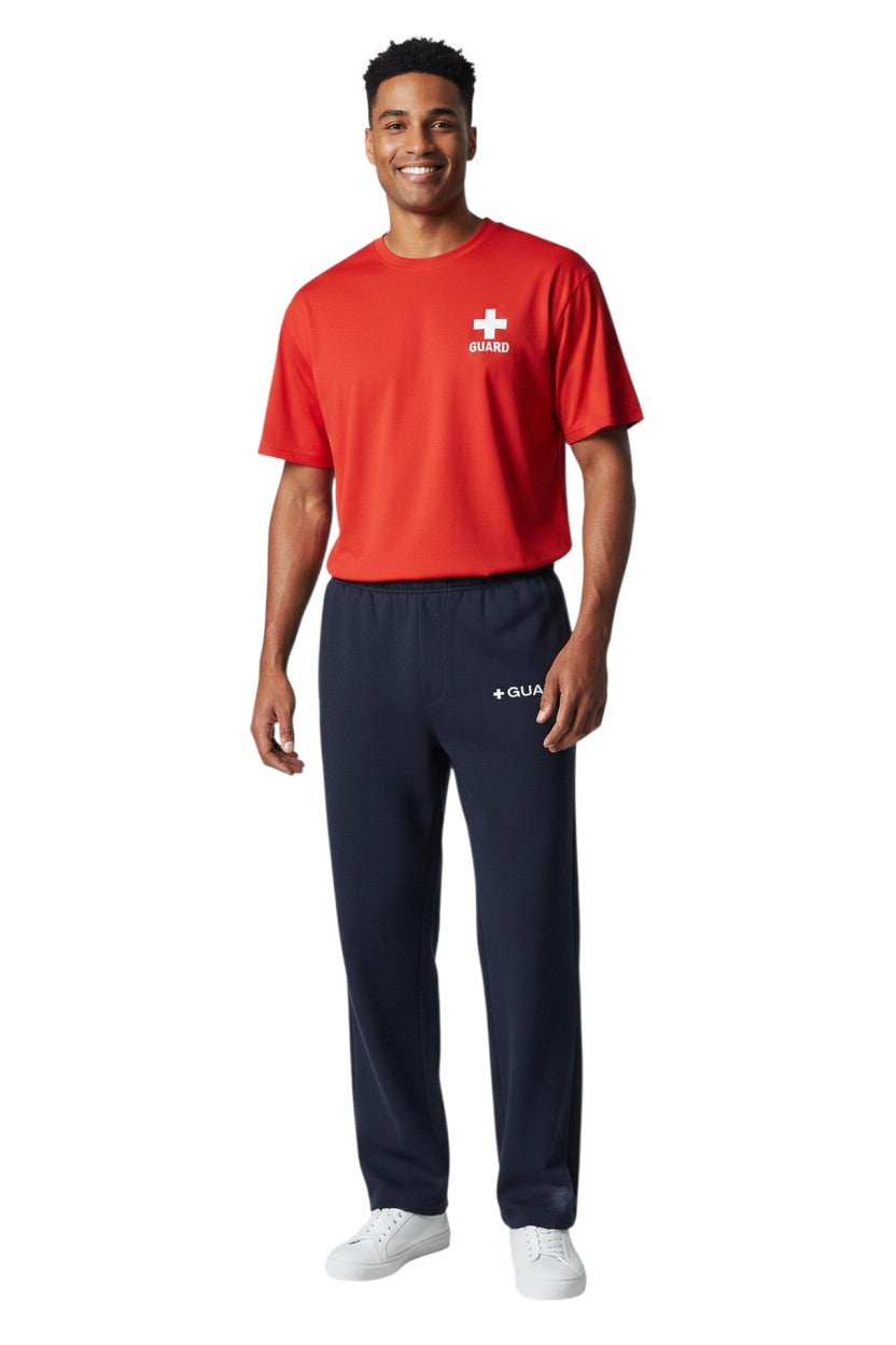 The Lifeguard Store navy blue sweatpants with drawstring and side pockets, featuring a white '+ GUARD' logo on the left thigh. Made of 50% Cotton/50% Polyester.