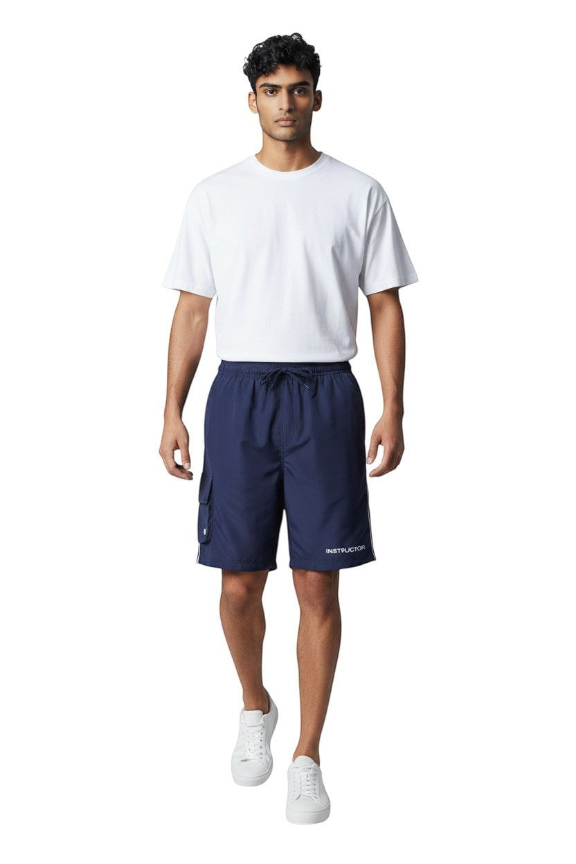 The Lifeguard Store Men's navy blue board shorts with liner, elastic waistband, cargo pocket, and "INSTRUCTOR" text detail.