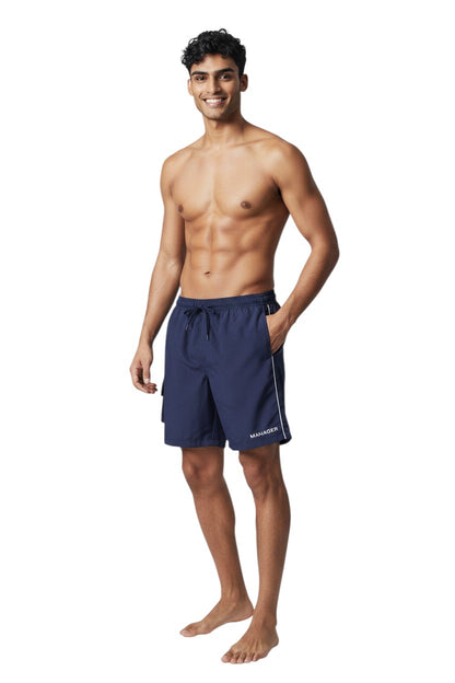The Lifeguard Store navy blue polyester board shorts with liner, elastic waistband, drawstring, cargo pocket, and "MANAGER" text.