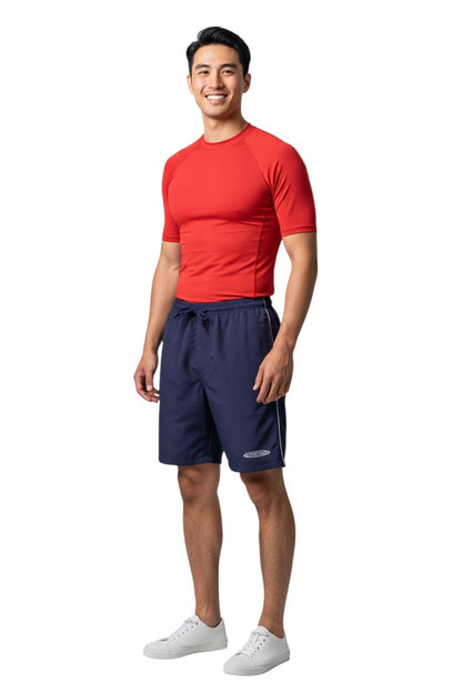 The Lifeguard Store navy blue polyester board shorts with white piping and embroidered logo. Elastic waistband with drawstring.
