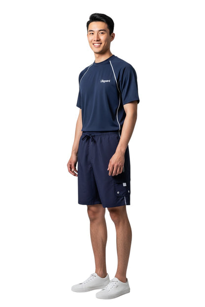 The Lifeguard Store navy blue polyester board shorts with white trim, elastic waistband, drawstring, and velcro pocket.