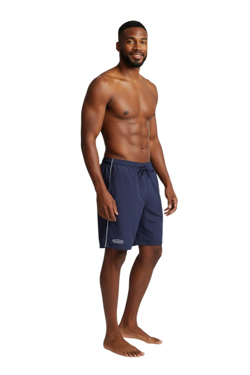 The Lifeguard Store navy blue polyester board shorts with white piping and drawstring waist. Features "MANAGER" logo.
