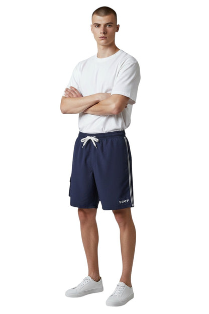 The Lifeguard Store navy blue polyester staff board shorts with liner, elastic waistband, drawstring, and cargo pocket.