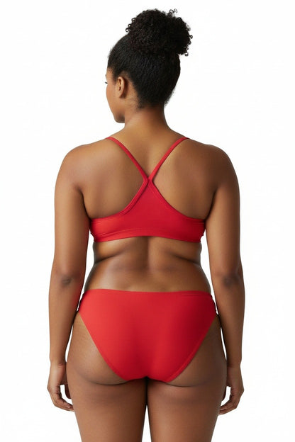 Back view of a woman wearing The Lifeguard Store red two-piece poly bikini with a cross-back strap design.