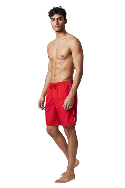 The Lifeguard Store red polyester board shorts with white piping and drawstring waist. Features UPF30+ protection.