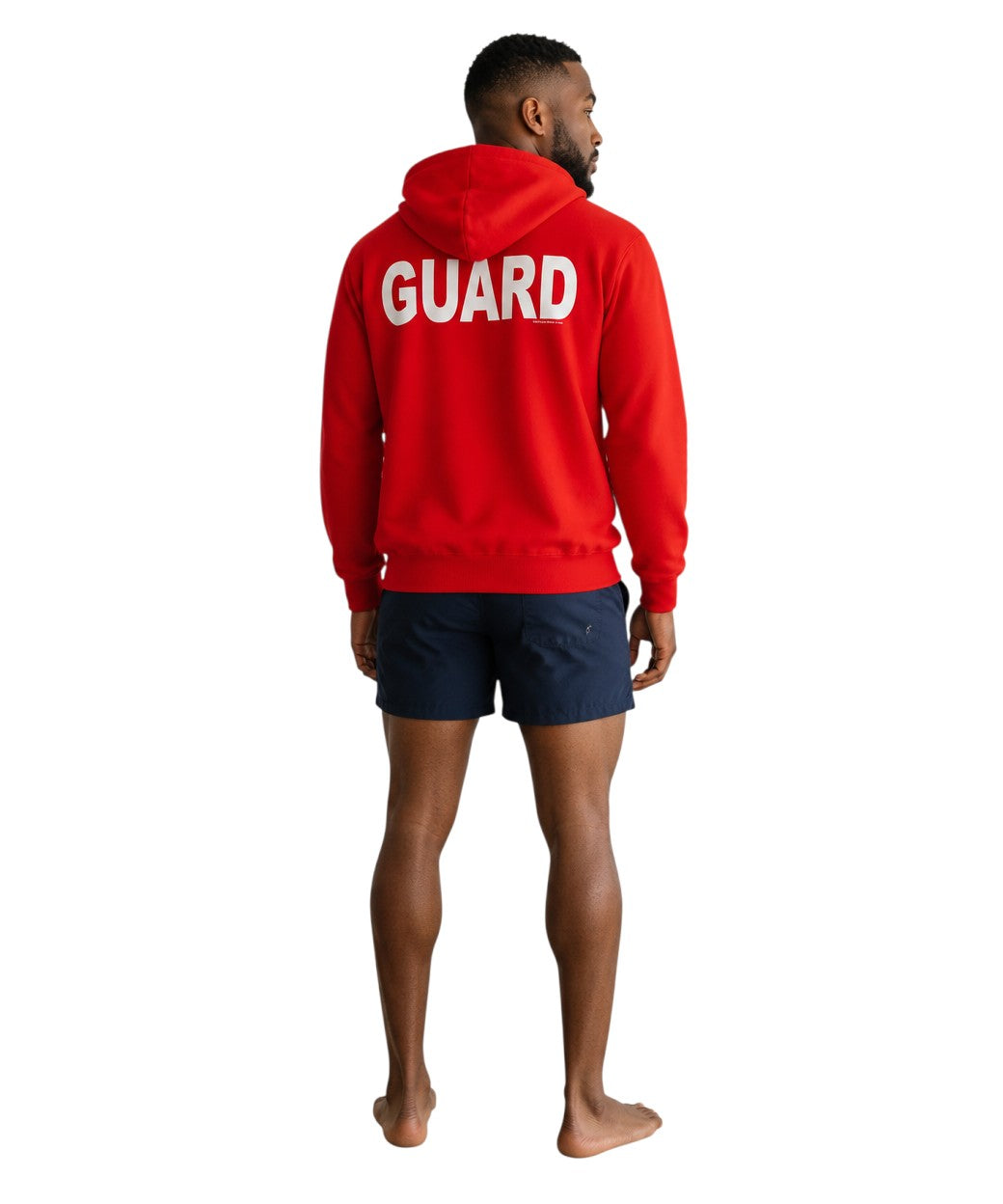 The Lifeguard Store red hooded sweatshirt with white GUARD logo on the back, worn by a man in navy swim shorts.