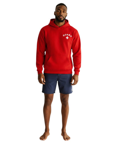 The Lifeguard Store red hooded sweatshirt with white GUARD logo, worn by a male model with navy blue shorts.