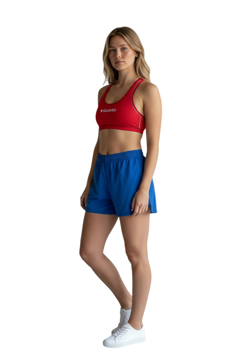 The Lifeguard Store red reversible racer back guard top with navy blue interior and white '+ GUARD' text.