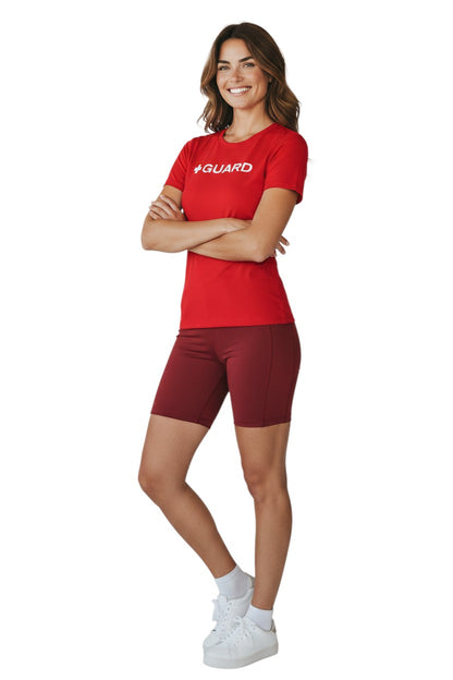 The Lifeguard Store red short sleeve crewneck rashguard with white + GUARD text. Polyester-spandex blend.