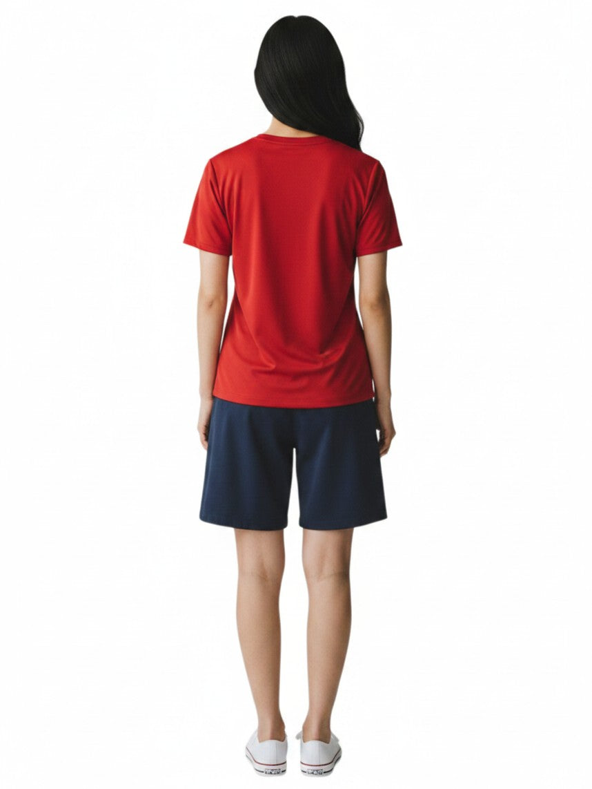 Back view of a woman wearing a red The Lifeguard Store short sleeve crew neck rashguard with navy blue shorts