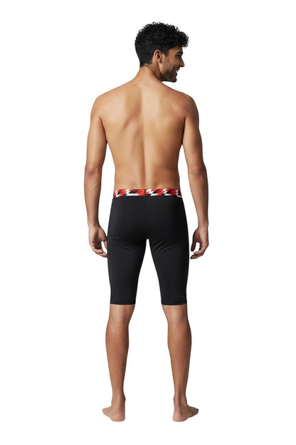 The Lifeguard Store RISE Sandies Swerve Poly Jammer swimsuit in black with a red and white geometric waistband. Made of 91% Polyester/9% Spandex.