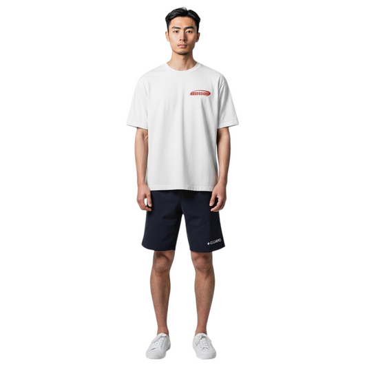 The Lifeguard Store white cotton Attendant tee worn by a model with navy shorts and white sneakers.