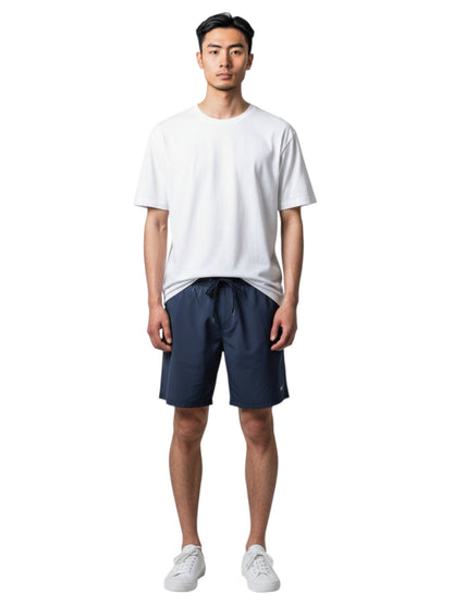 Male model wearing The Lifeguard Store white short sleeve crew neck rashguard and navy blue swim shorts