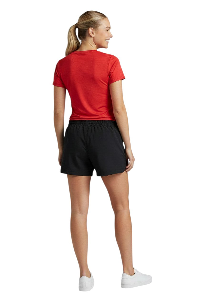 The Lifeguard Store black polyester YMCA instructor roll shorts with white logo and drawstring. Model wears red t-shirt and white sneakers.